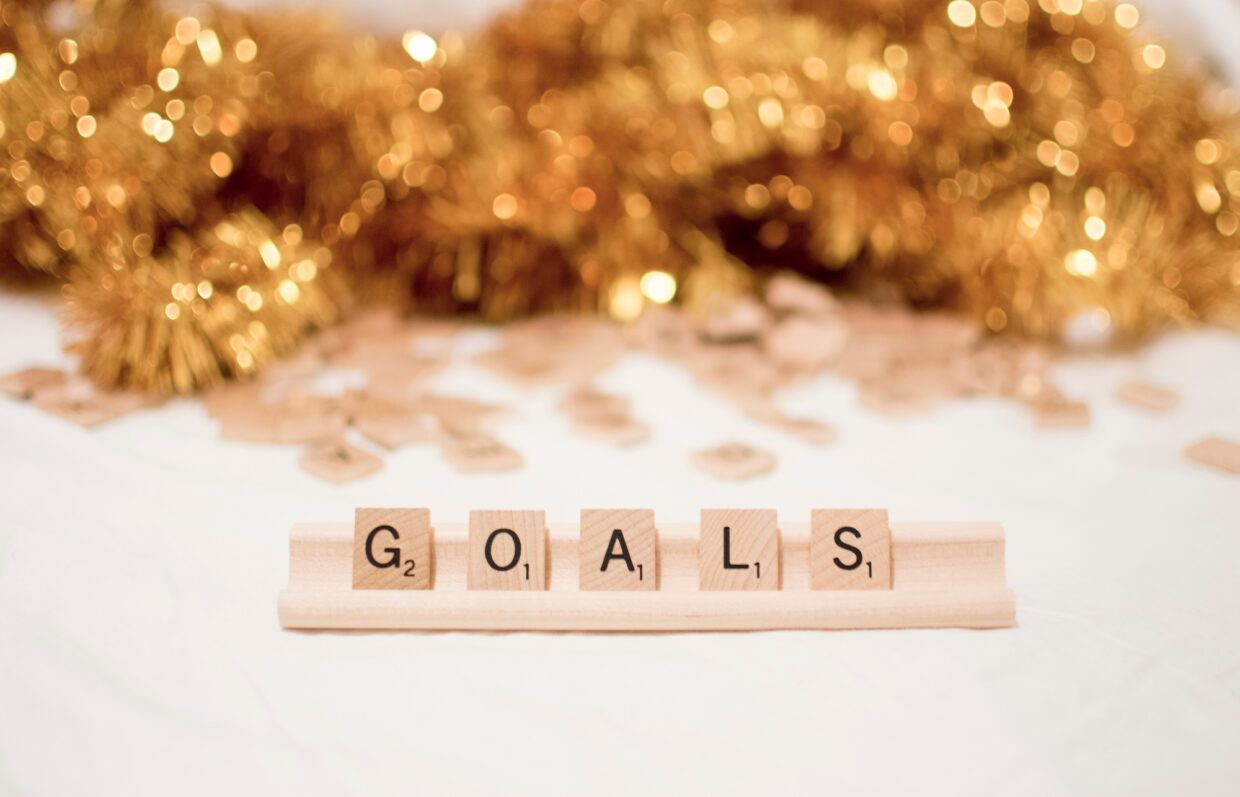 Scrabble letter goals with gold glitter in background.